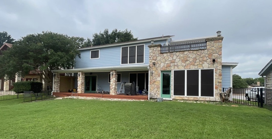 Back of home after renovation with new blue siding